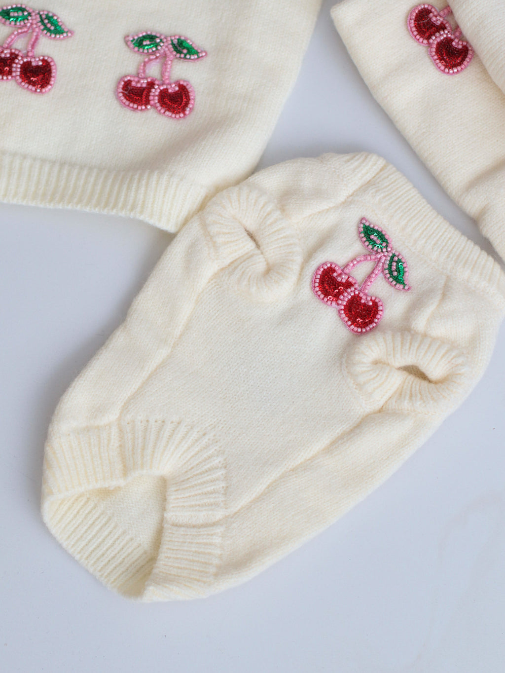 Milk-colored sleeveless sweater with Miu Miu print