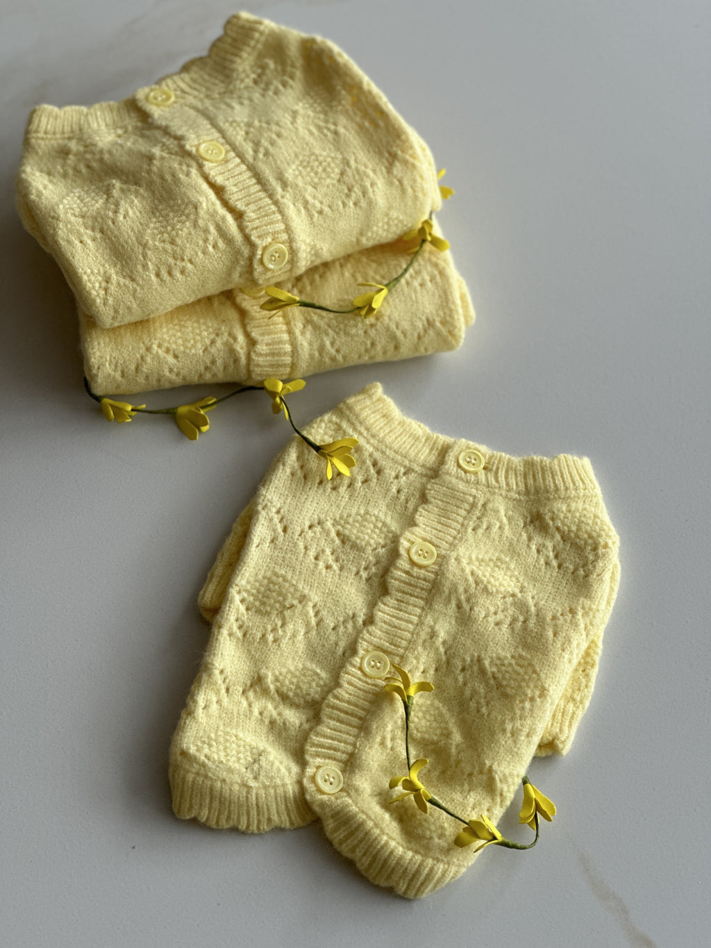 Светр жовтого кольору з ґудзиками на спинці