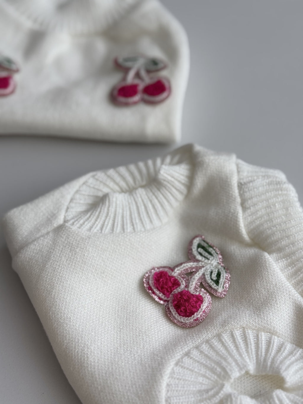 Светр молочного кольору з нашивками Cherry