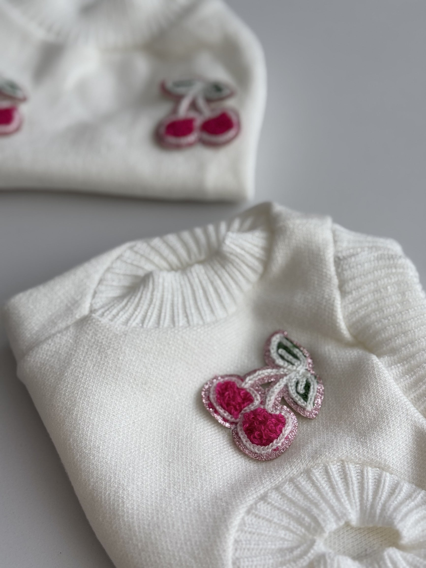 Светр молочного кольору з нашивками Cherry