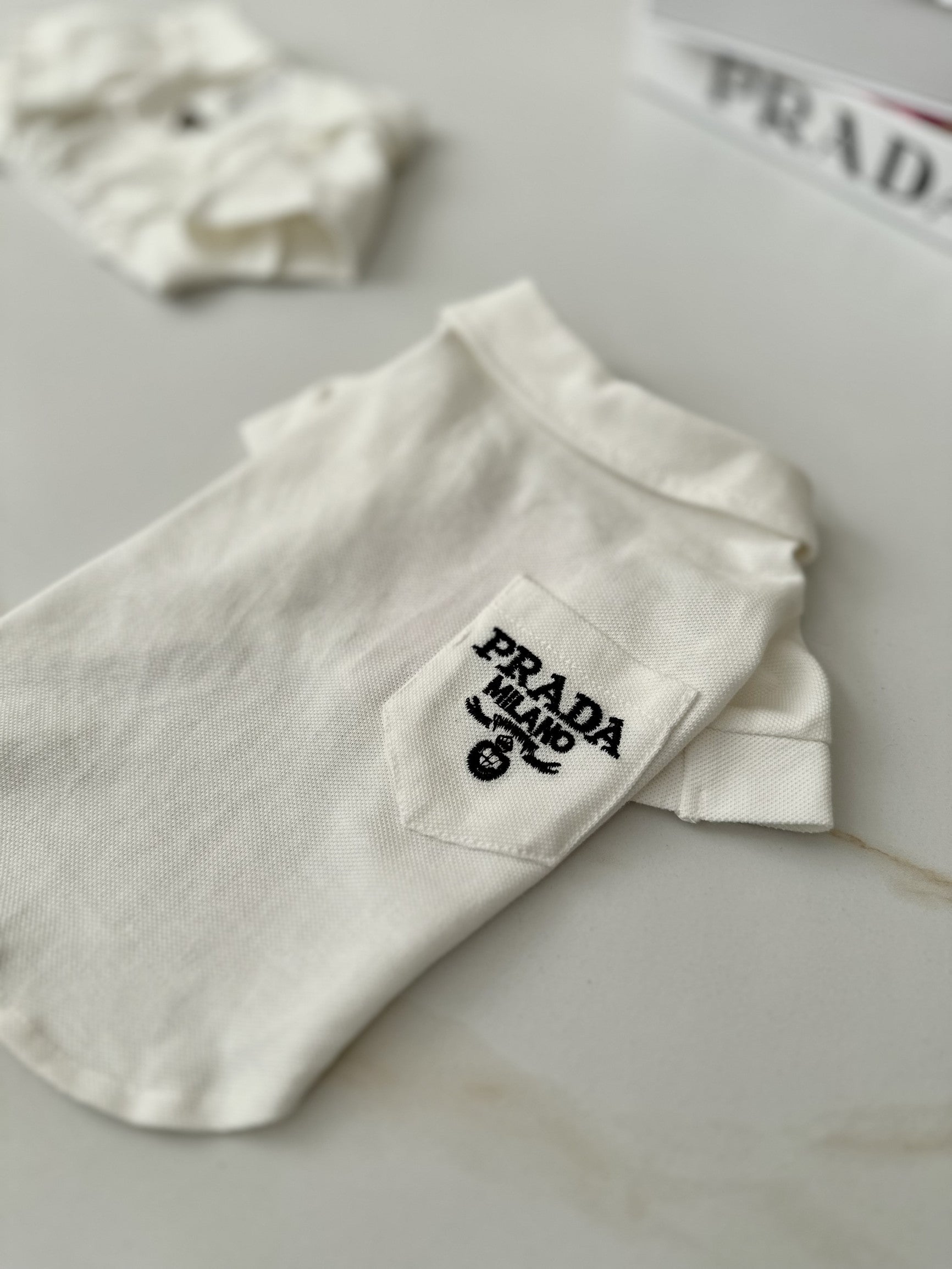 Футболка-поло білого кольору з принтом Prada