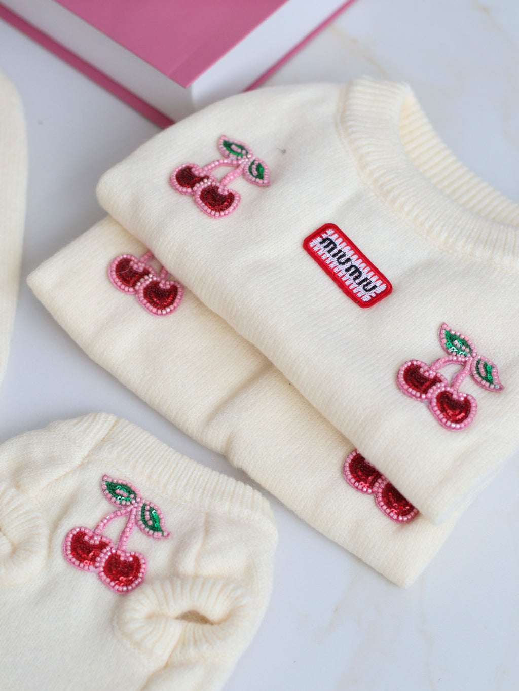 Milk-colored sleeveless sweater with Miu Miu print